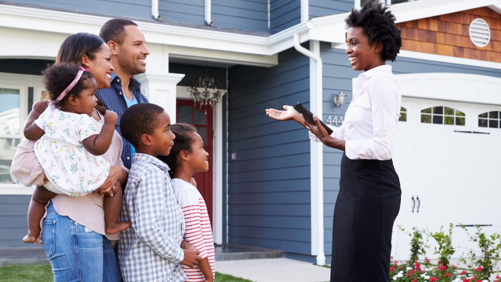 Real estate agent showing a family a house, closer in